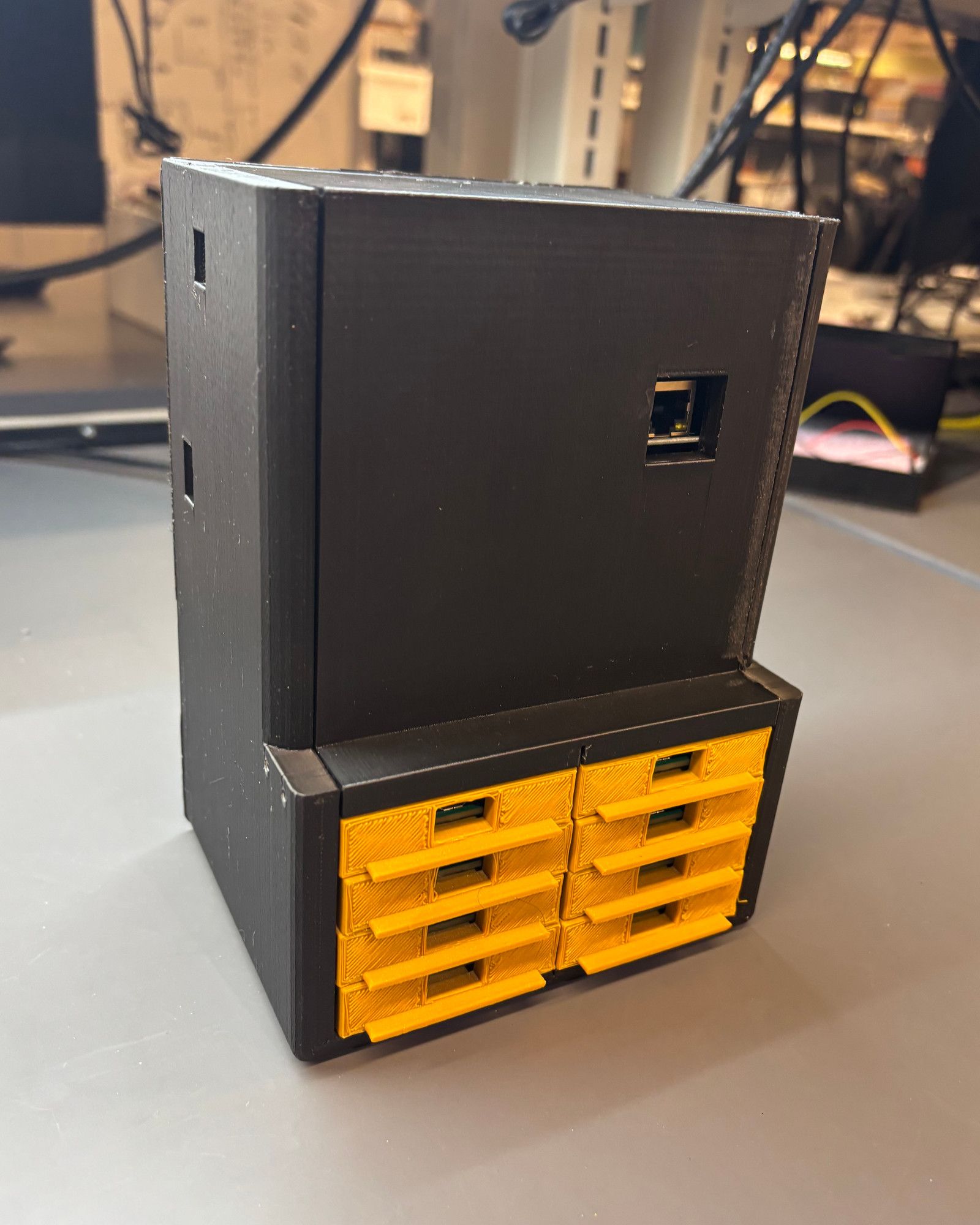 The assembled black BoilerNet enclosure with six visible yellow removable module trays.